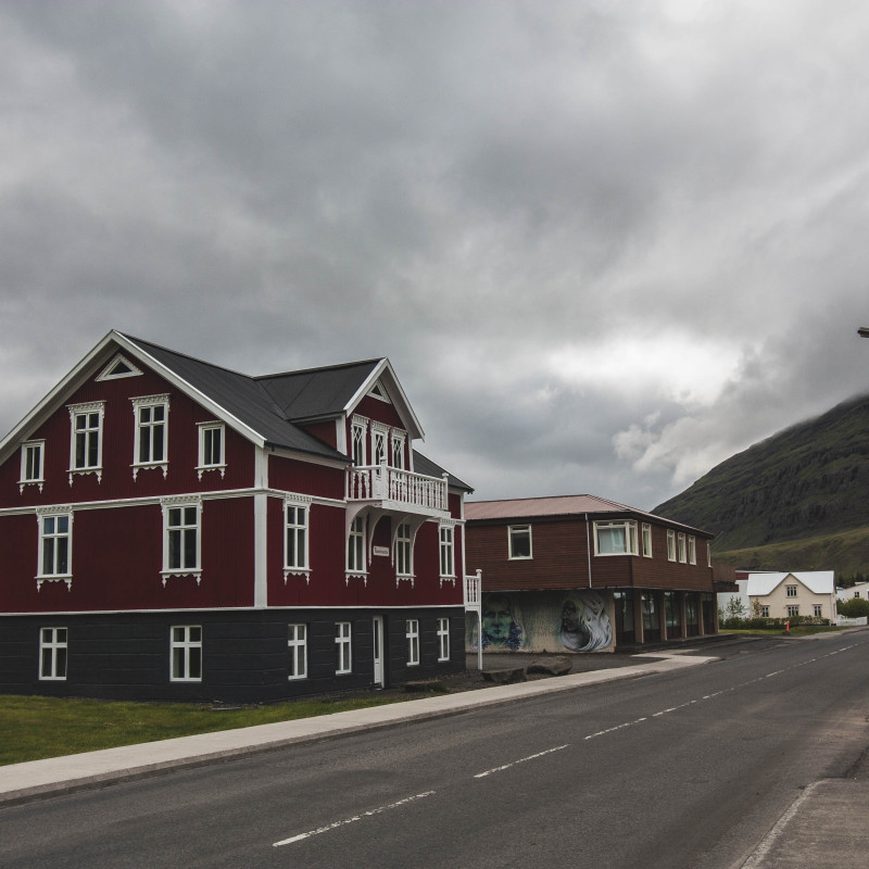 EIn rotes Holzhaus am Straßenrand.