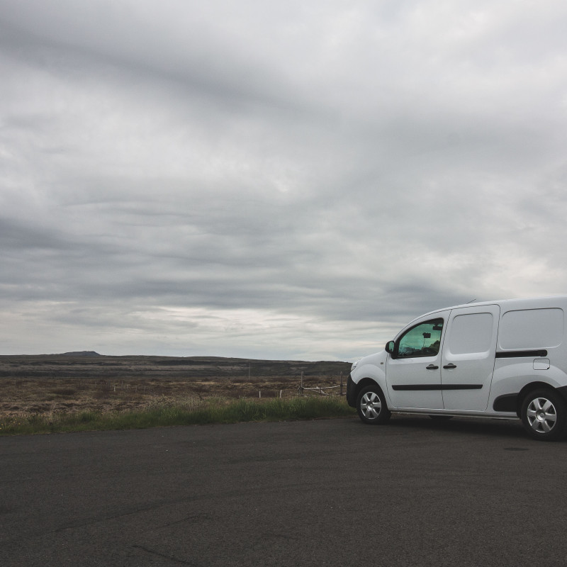 Ein weißer Campervan vor einer öden Landschaft.