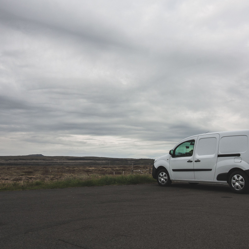 Ein weißer Campervan vor einer öden Landschaft.