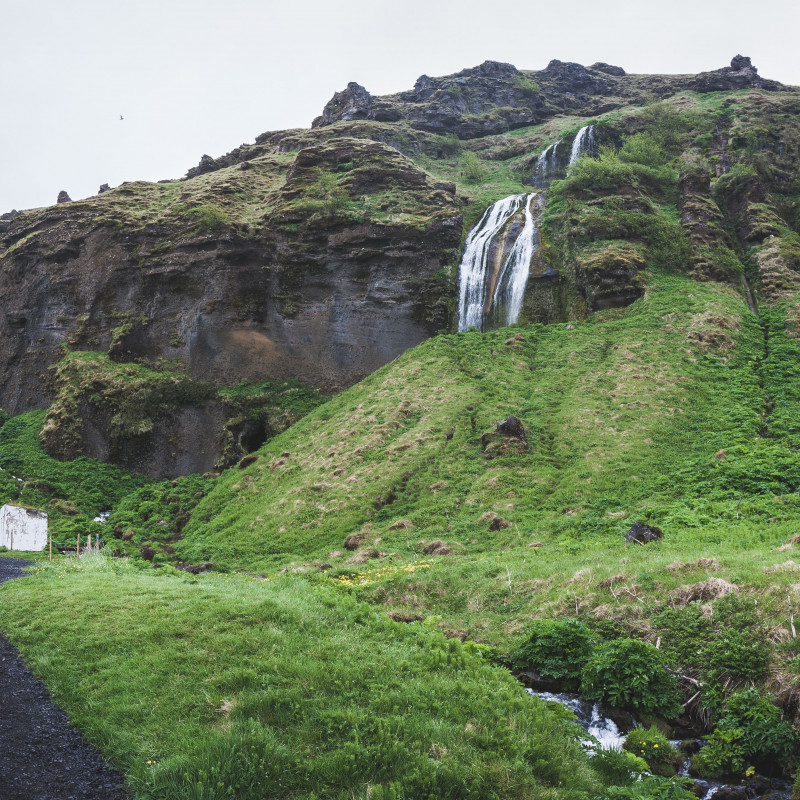 Ein Wasserfall und sehr viel grüne Landschaft.
