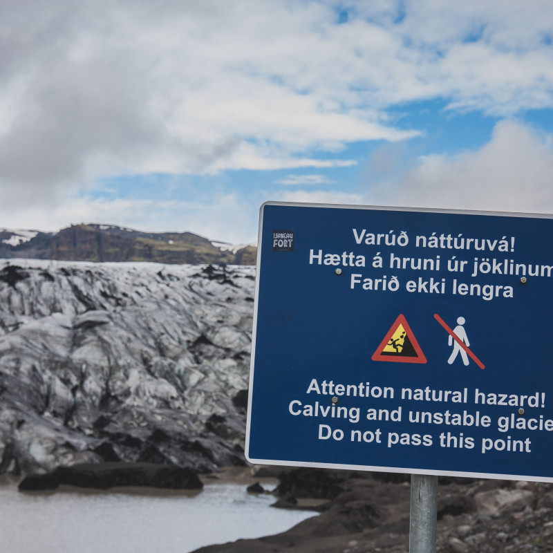 Warnschild vor einem Gletscher.