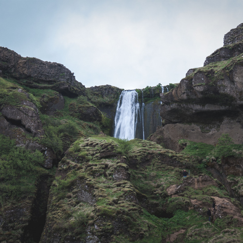 Ein Wasserfall hinter einigen Felsen.