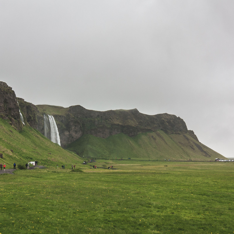 Viel grüne Wiese und im Hintergrund ein großer Wasserfall.
