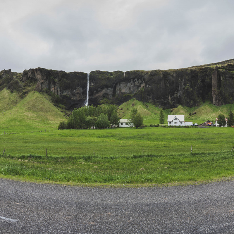 Panorama-Bild der Straße mit einer kleinen Siedlung im Hintergrund.