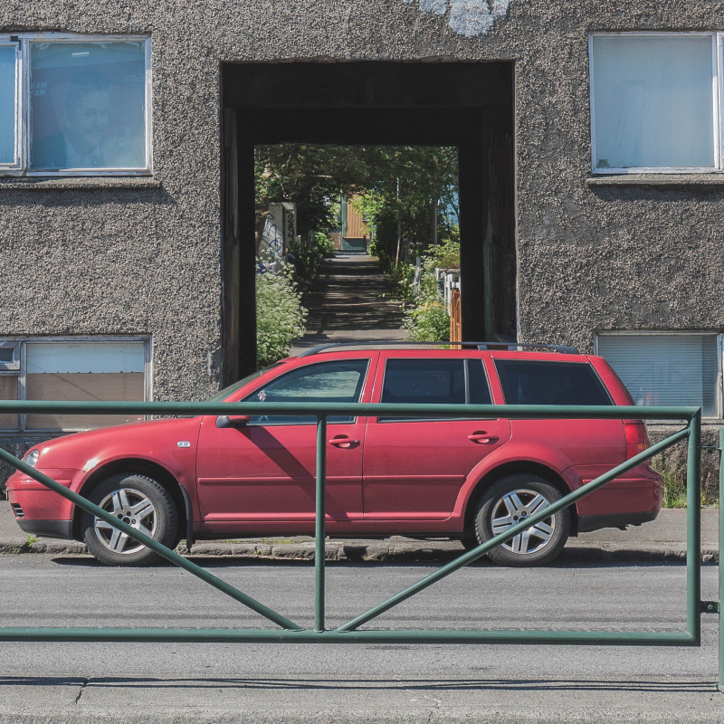 Ein Auto steht vor einem Durchgang durch ein Haus.