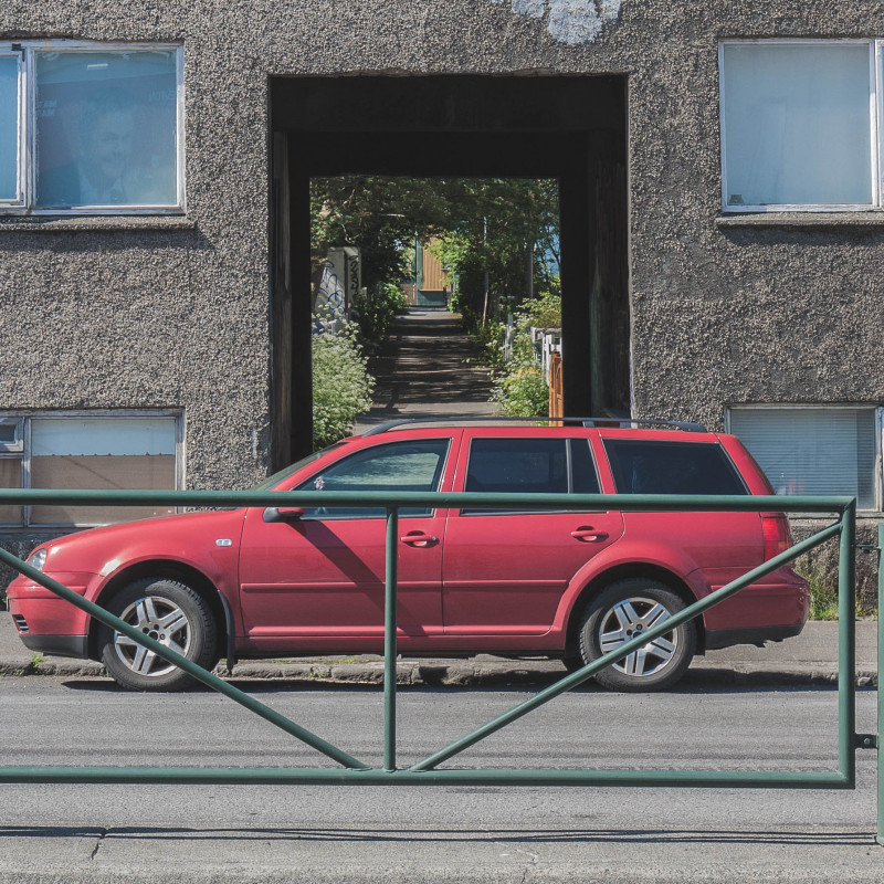 Ein Auto steht vor einem Durchgang durch ein Haus.