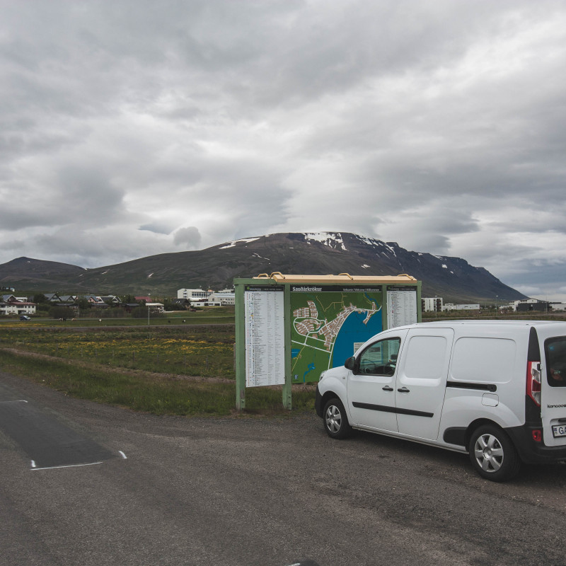 Campervan vor einer Informationstafel.