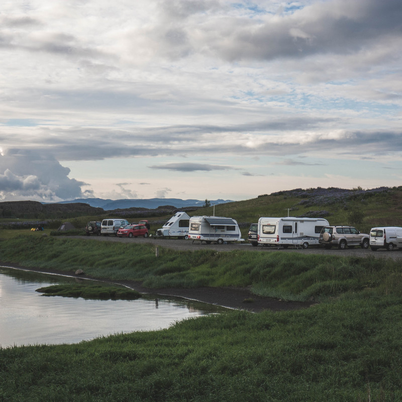 Wohnmobile und Camper am Abend an einem See.