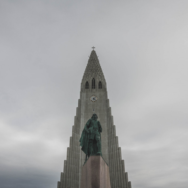 Eine Statue vor einem Kirchturm.