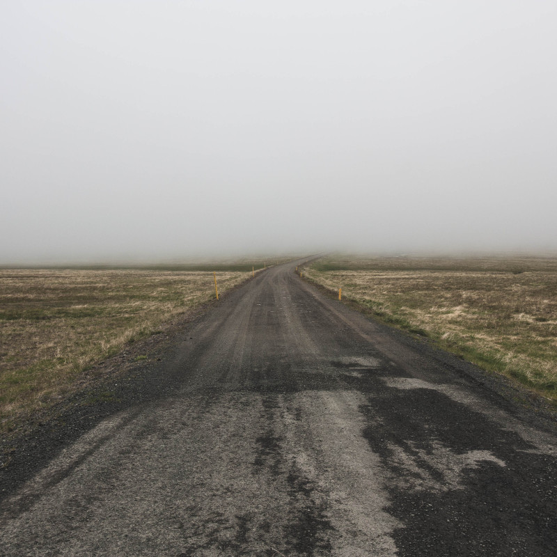 Eine Straße führt in den Nebel.