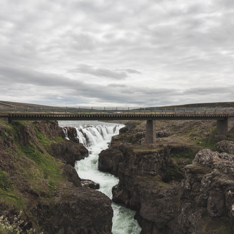 Wasserfall hinter einer Brücke.