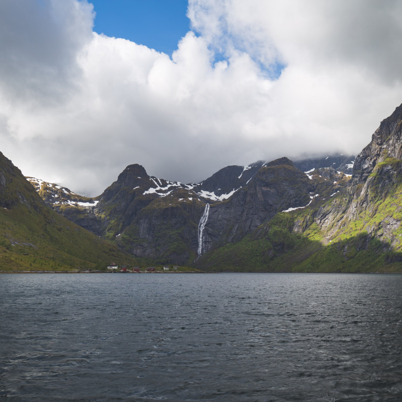 Berge und Meer. Im Hintergrund ein Wasserfall.
