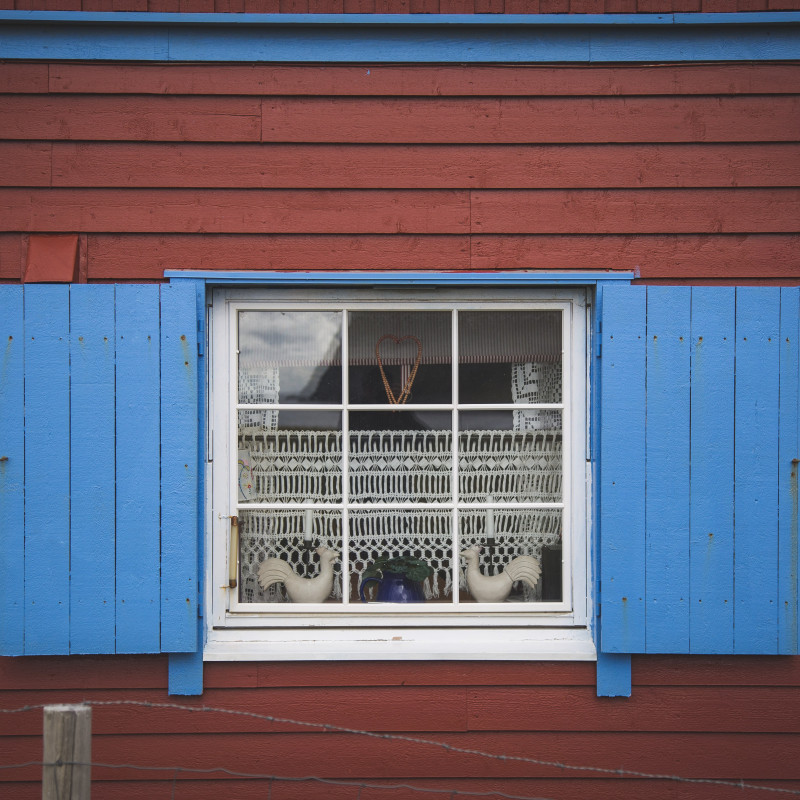 Blaues Fenster an rotem Haus.