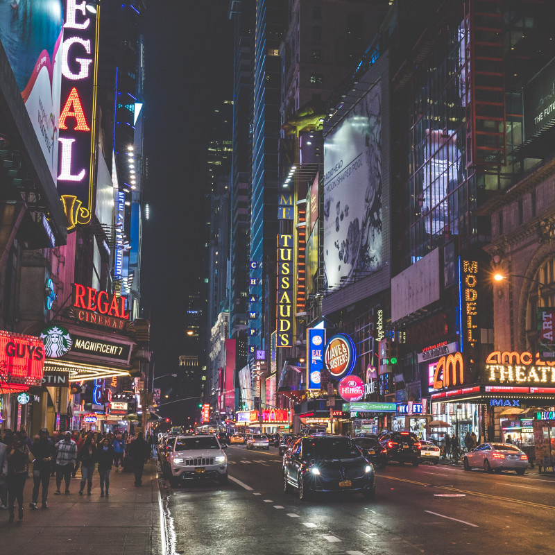 New York bei Nacht: Viele Lichter und Werbetafeln an Hochhäusern.