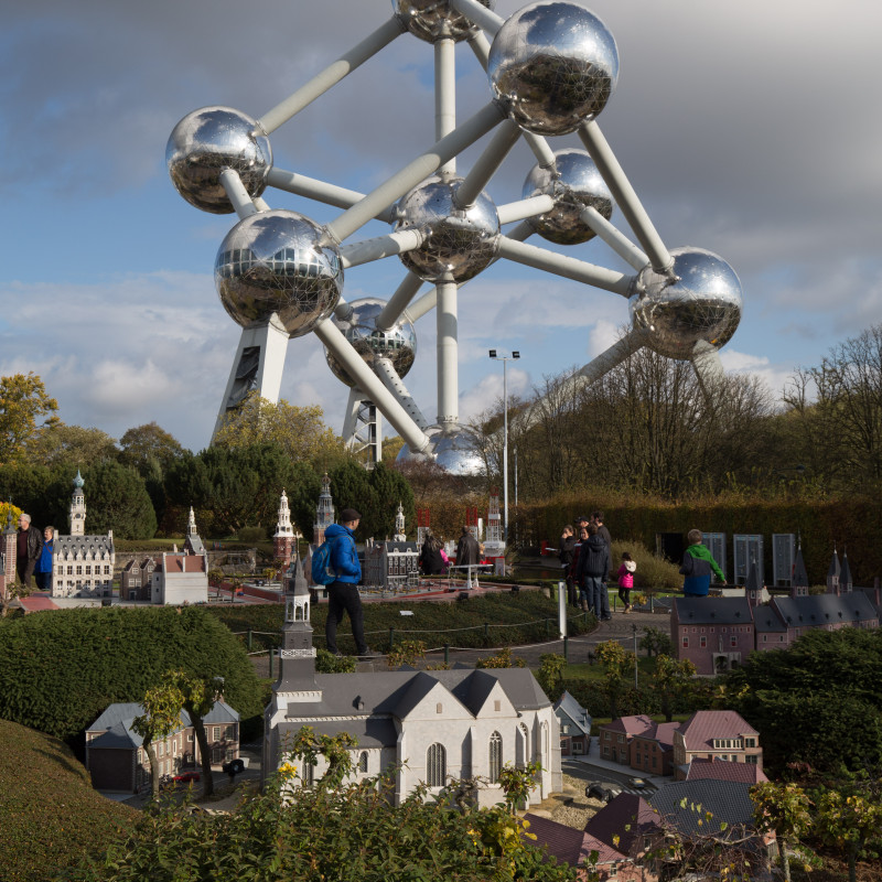 Kleine Gebäude in "Mini Europe" mit Atomium im Hintergrund.