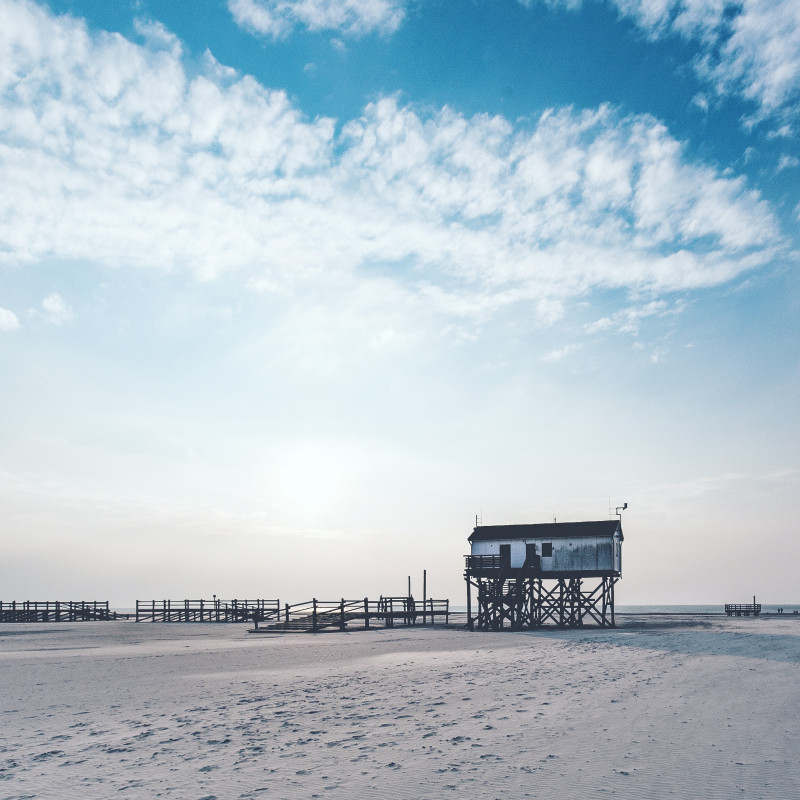 Strand von St. Peter-Ording. Im Hintergrund ein Haus auf Stelzen.