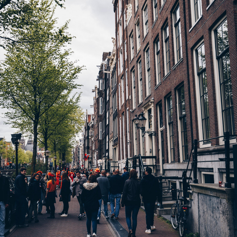 Menschen in Gassen in Amsterdam am Königstag.