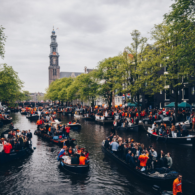 Boote auf Grachten am Königstag in Amsterdam.