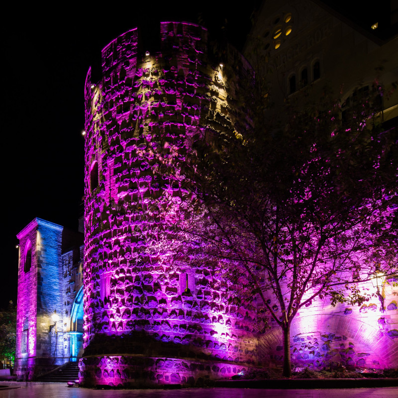 Das Tor der Stadtmauer ist bunt angestrahlt.