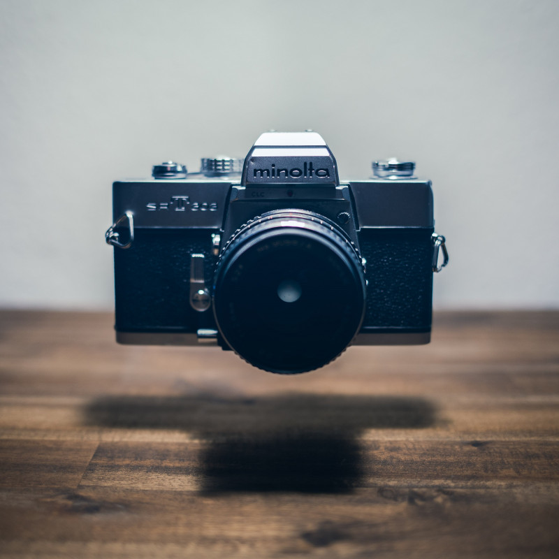 Eine Minolta-Spiegelreflexkamera schwebt über dem Schreibtisch.