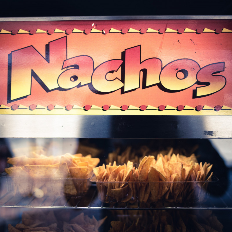 Schriftzug "Nachos" auf einem Glaskasten.
