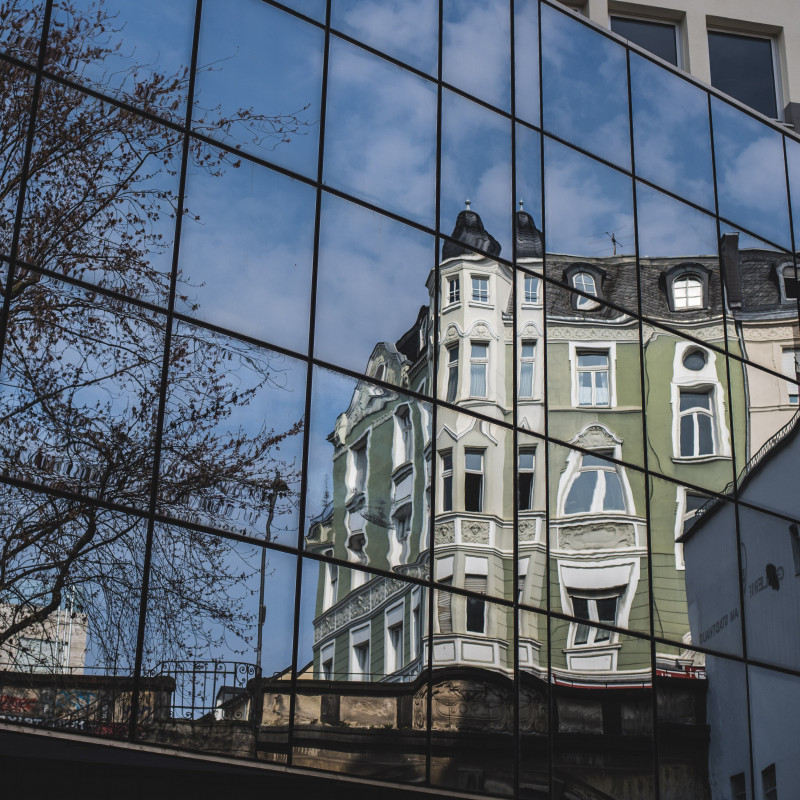 Ein altes Gebäude spiegelt sich in einer modernen Fassade.