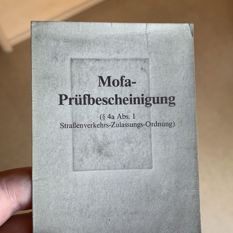 Eine abgenutzte Mofa-Prüfbescheinigung.