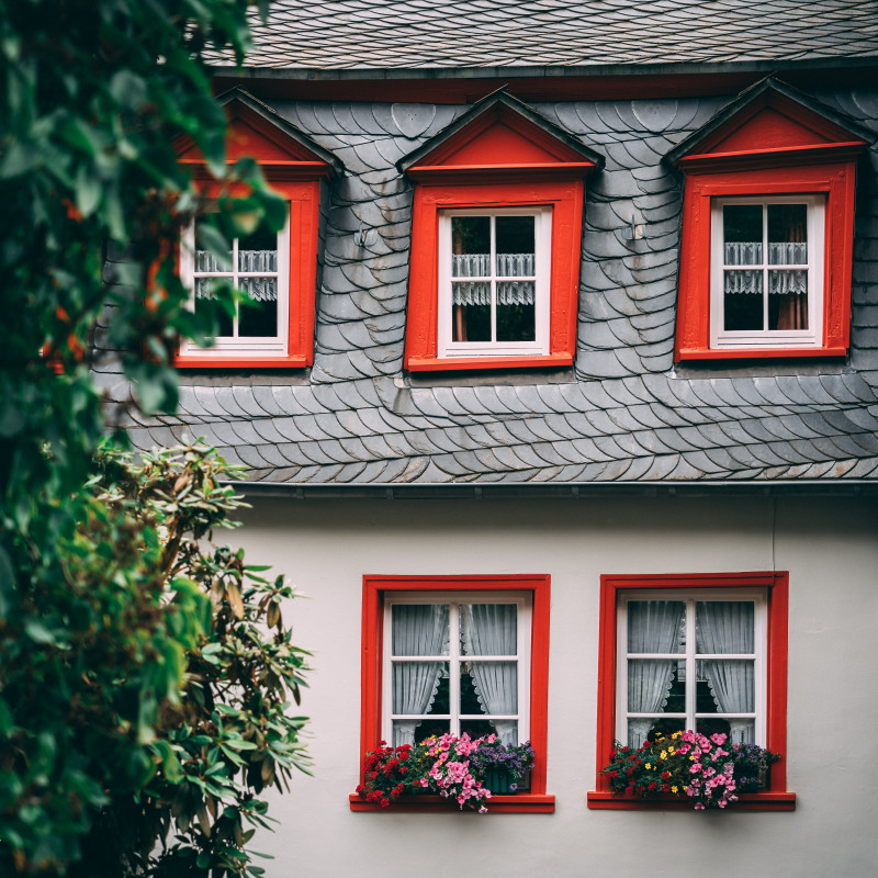 Haus mit roten Fensterrahmen.