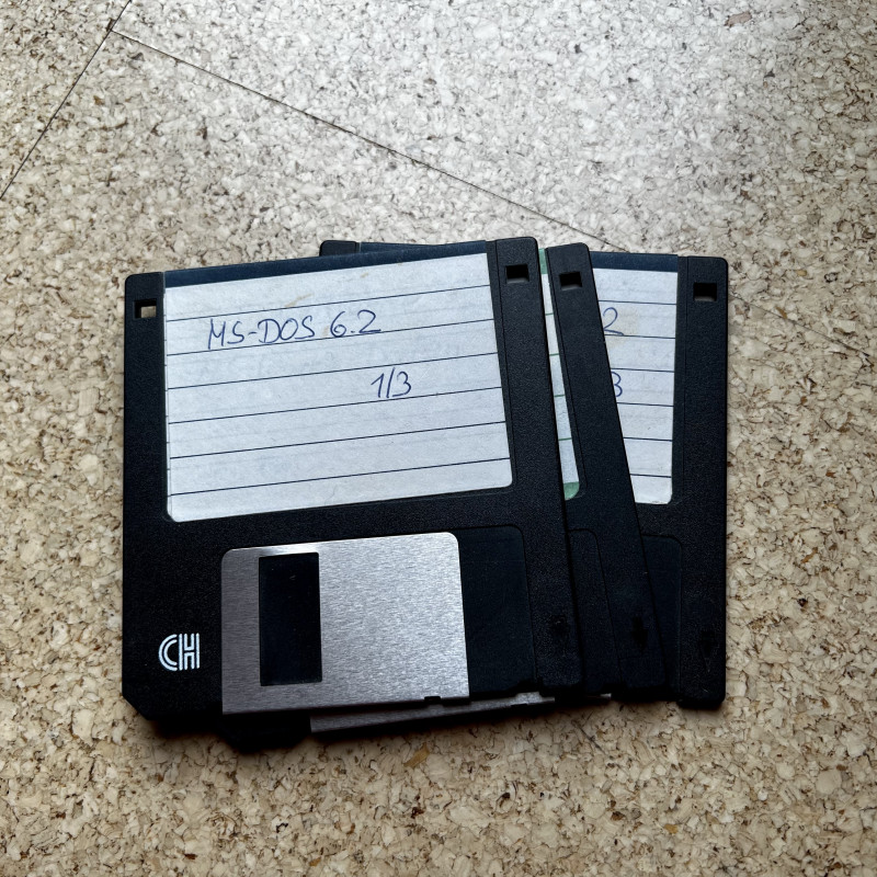 Drei Disketten auf einem Haufen, die oberste ist mit "MS-DOS 6.2" beschriftet.