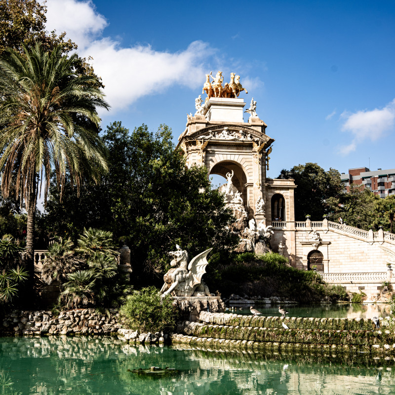 Ein Teich mit einem großen Pavillion auf dem eine goldene Statue steht.