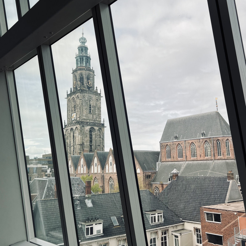 Ein Kirchturm, passgenau fotografiert durch einen schrägen Fensterrahmen.