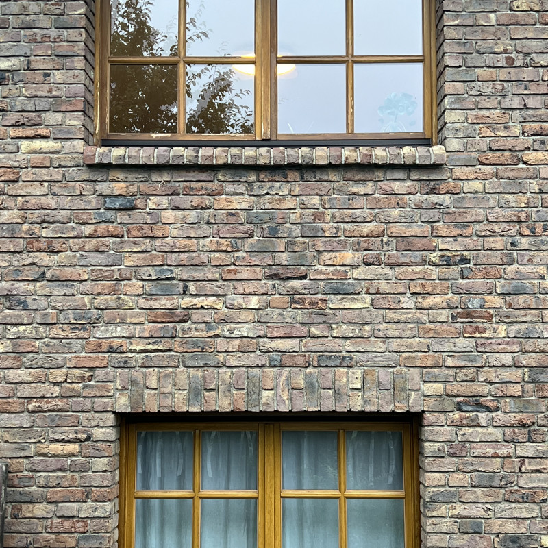 Zwei zweiflügelige Fenster übereinander in einer Klinkerwand.