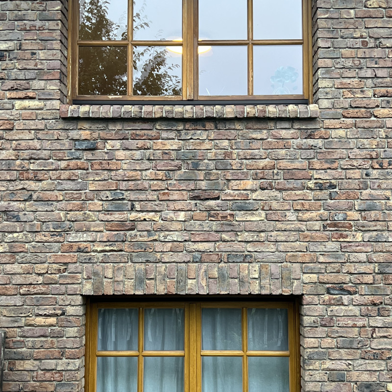 Zwei zweiflügelige Fenster übereinander in einer Klinkerwand.