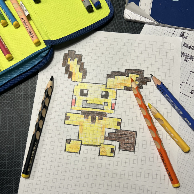 Ein auf kariertem Papier gemaltes, gelbes Pichu-Pokémon.